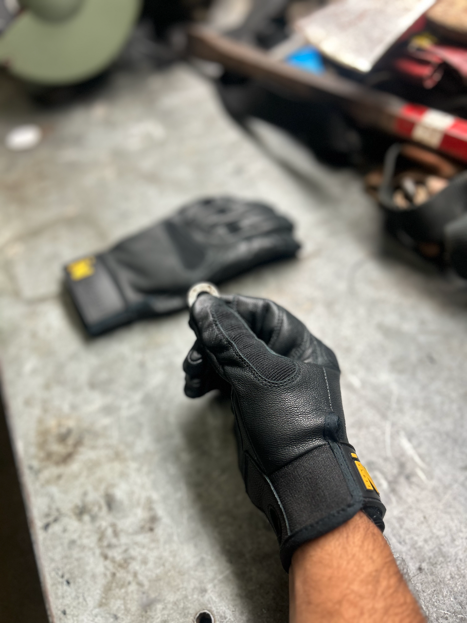 Support Glove holding small washer between fingers.